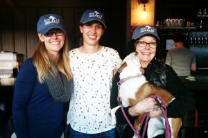 3 volunteers wearing ACC hats at the party.